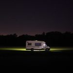 Image of RV in the middle of an open field at night